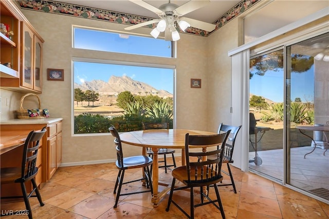 tiled dining room featuring ceiling fan and a mountain view