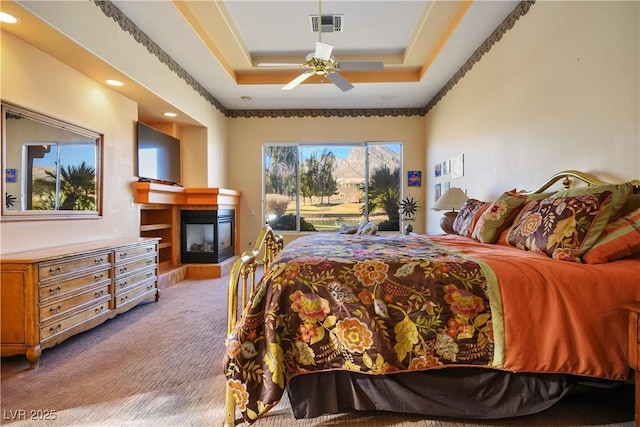 bedroom featuring access to outside, a raised ceiling, light colored carpet, and ceiling fan