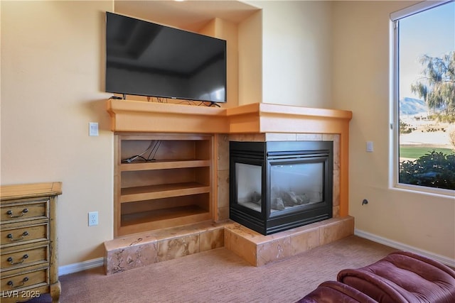 unfurnished living room with a tiled fireplace and carpet