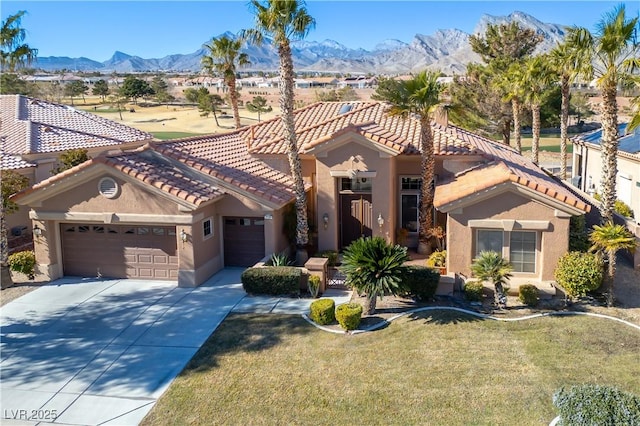 mediterranean / spanish-style home with a garage, a front yard, and a mountain view