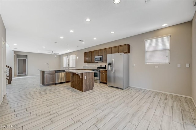 kitchen with plenty of natural light, a breakfast bar, stainless steel appliances, and a kitchen island