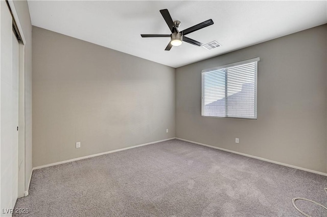 carpeted spare room with ceiling fan