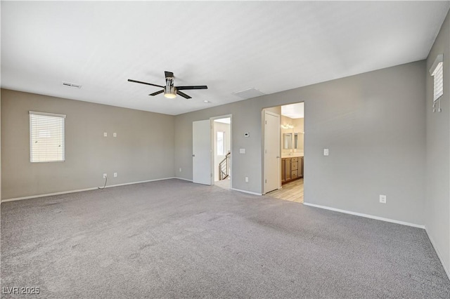 empty room with ceiling fan and light carpet