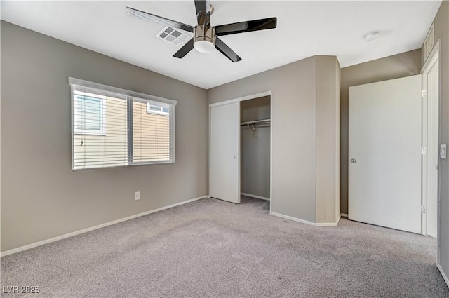 unfurnished bedroom featuring ceiling fan, a closet, and light carpet