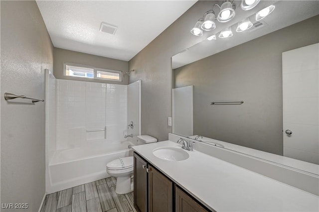 full bathroom with toilet, a textured ceiling, shower / bath combination, and vanity