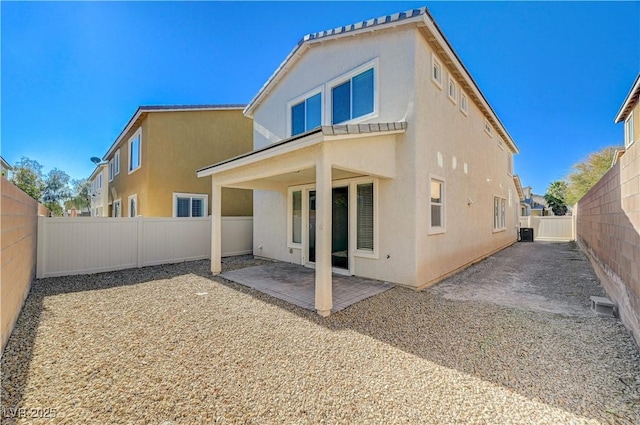 rear view of house featuring central AC unit and a patio