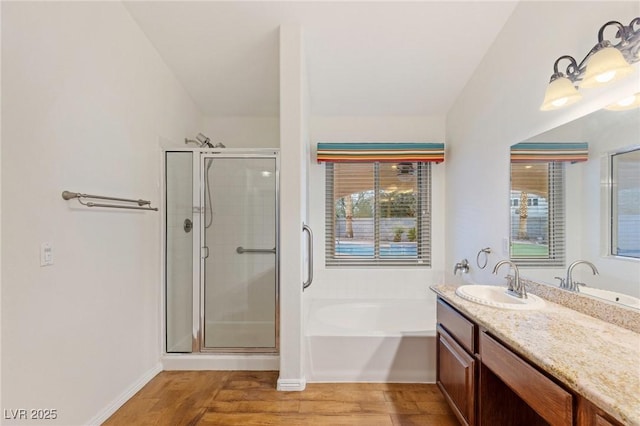 bathroom with shower with separate bathtub, a healthy amount of sunlight, hardwood / wood-style floors, and vanity