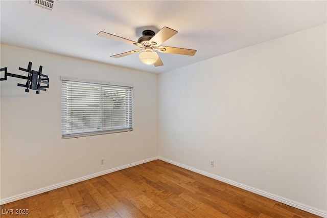 empty room with hardwood / wood-style floors and ceiling fan