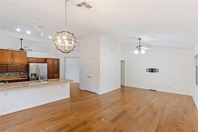 kitchen featuring ceiling fan with notable chandelier, light hardwood / wood-style floors, stainless steel fridge with ice dispenser, and pendant lighting