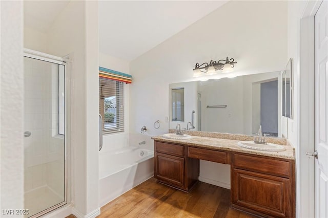 bathroom with lofted ceiling, hardwood / wood-style floors, vanity, and shower with separate bathtub