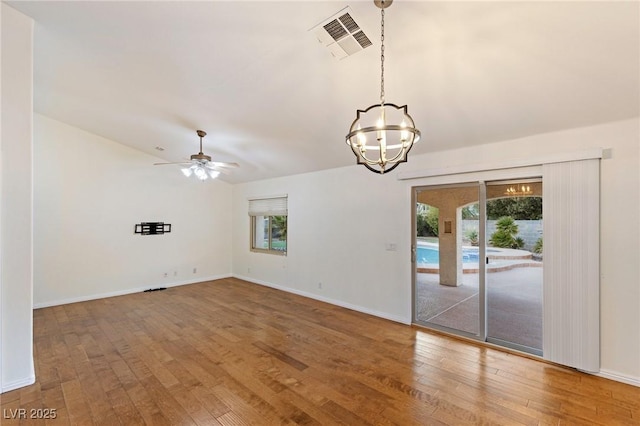 unfurnished room with wood-type flooring and ceiling fan with notable chandelier