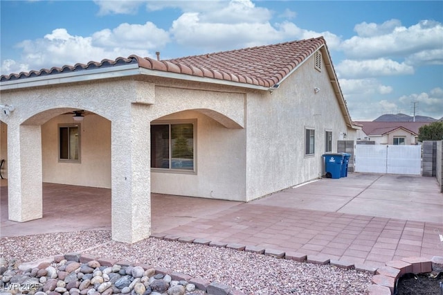 back of property with a patio and ceiling fan