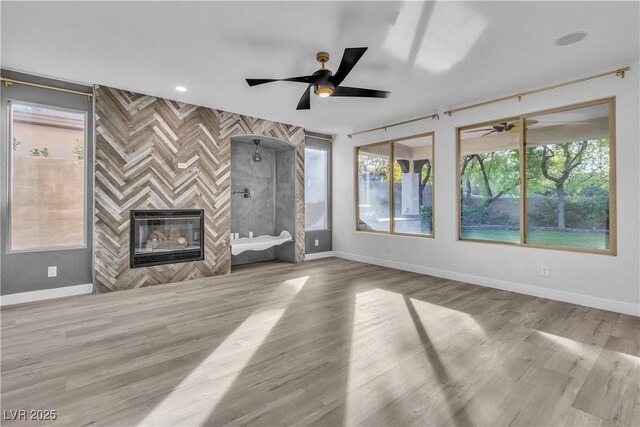 unfurnished living room with light wood-type flooring and a tiled fireplace