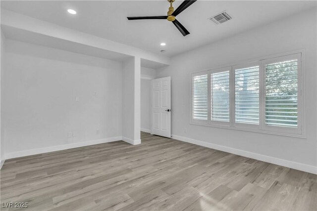 empty room featuring ceiling fan, light hardwood / wood-style floors, and plenty of natural light