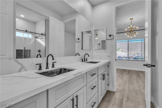 bathroom with wood-type flooring, vanity, a chandelier, and plenty of natural light