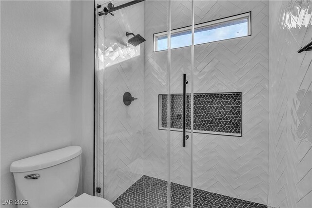 bathroom with an enclosed shower and toilet