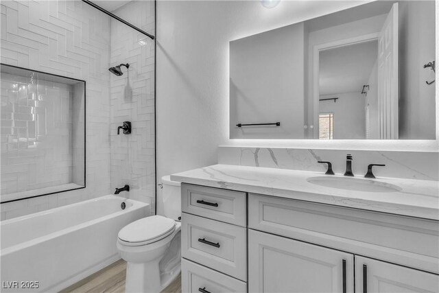 full bathroom with toilet, tiled shower / bath combo, wood-type flooring, and vanity