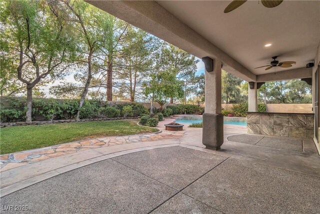 view of patio / terrace with ceiling fan and a fenced in pool