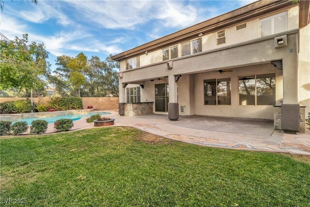 rear view of house with a lawn, a patio area, ceiling fan, and a fenced in pool