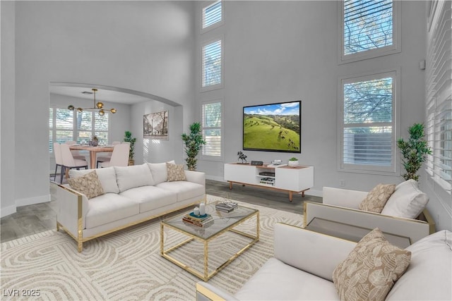 living room with a towering ceiling and wood-type flooring