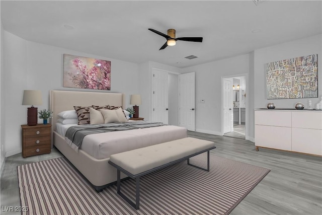 bedroom featuring connected bathroom, ceiling fan, and light hardwood / wood-style flooring