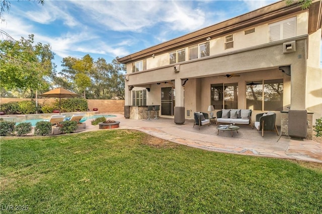 back of house featuring ceiling fan, a lawn, a patio area, and outdoor lounge area