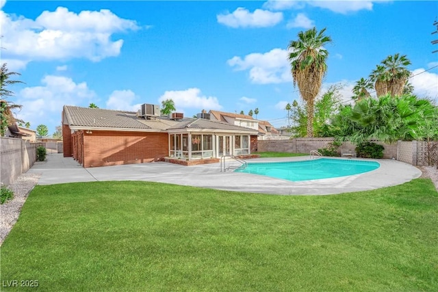 back of house featuring cooling unit, a yard, a fenced in pool, and a patio area