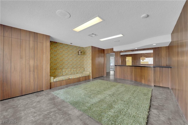 interior space featuring wooden walls and a textured ceiling