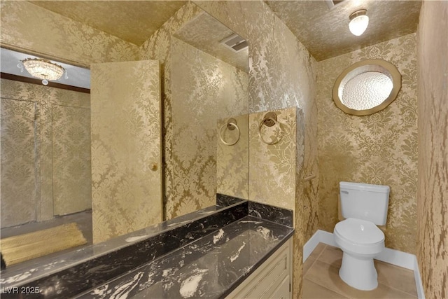 bathroom featuring vanity, tile patterned floors, and toilet