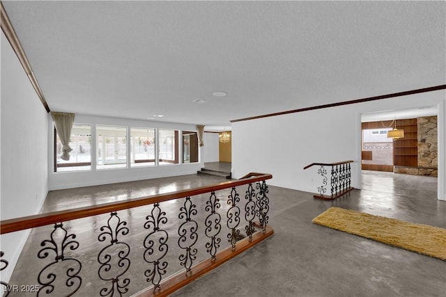 corridor featuring crown molding and a textured ceiling