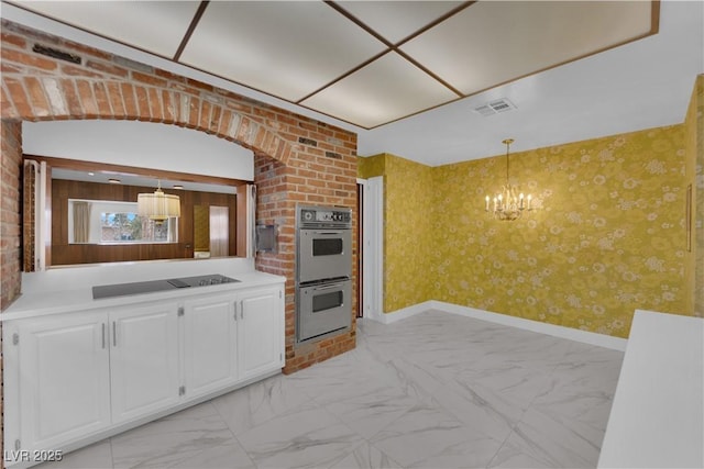 kitchen with double oven, decorative light fixtures, white cabinetry, black electric stovetop, and a notable chandelier