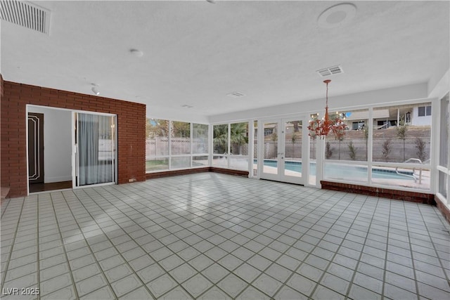 unfurnished sunroom featuring an inviting chandelier