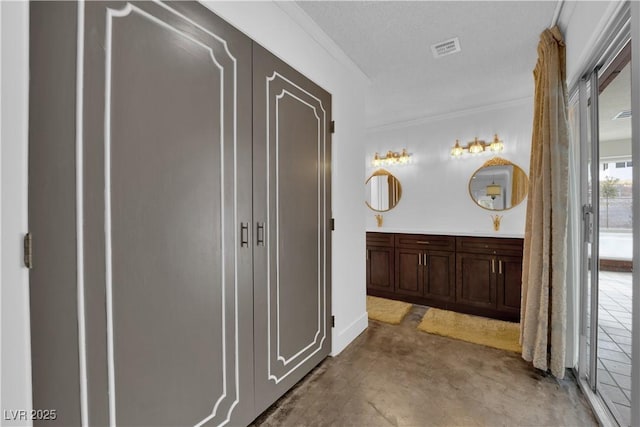 bathroom featuring ornamental molding, concrete floors, and vanity