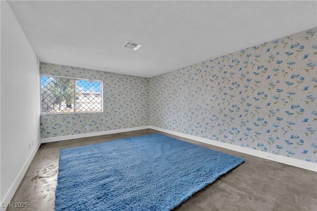 carpeted empty room featuring a textured ceiling