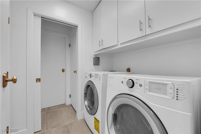 clothes washing area featuring cabinets, light tile patterned flooring, and independent washer and dryer