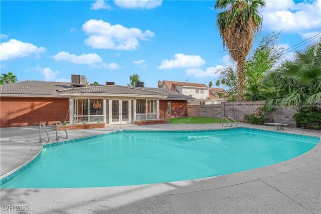 view of pool featuring cooling unit and a diving board