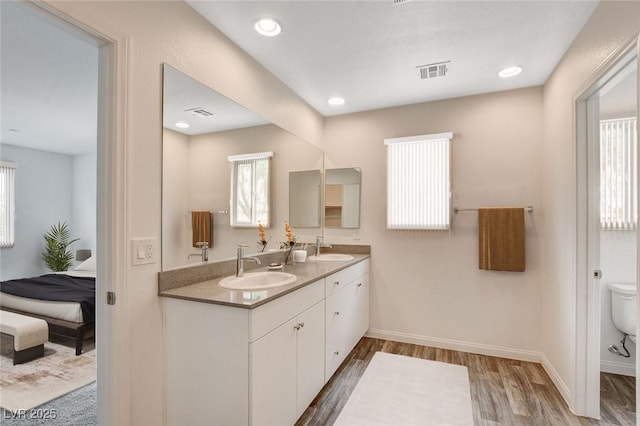 bathroom with toilet, vanity, and hardwood / wood-style floors