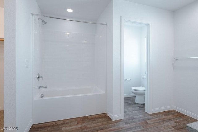 bathroom with toilet,  shower combination, and wood-type flooring