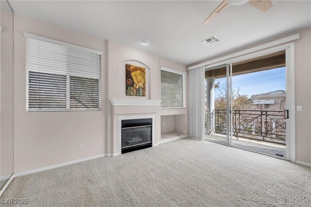 unfurnished living room with ceiling fan and carpet flooring