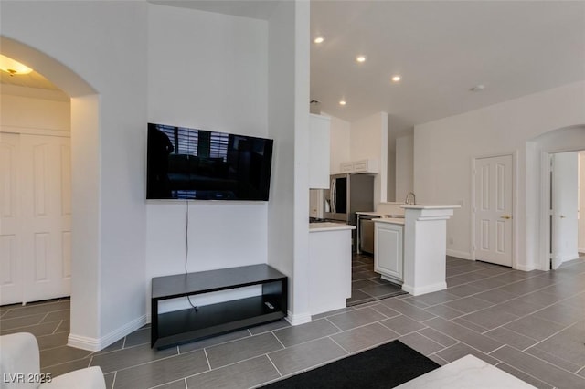 living room featuring sink and vaulted ceiling