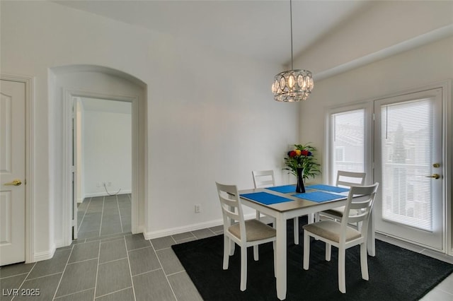 dining area featuring dark tile patterned flooring and a chandelier