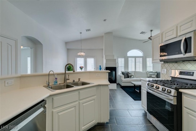 kitchen with sink, stainless steel appliances, white cabinetry, and decorative backsplash