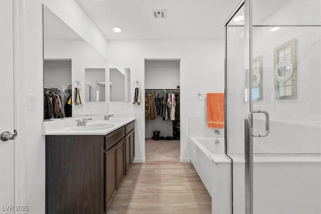 bathroom featuring shower with separate bathtub, vanity, and hardwood / wood-style floors