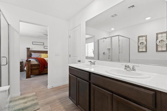 bathroom with ceiling fan, an enclosed shower, and vanity