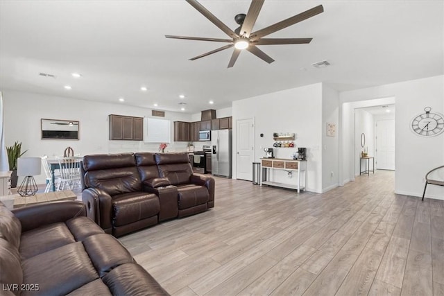 living room featuring ceiling fan and light wood-type flooring