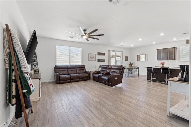 living room with ceiling fan and light hardwood / wood-style floors