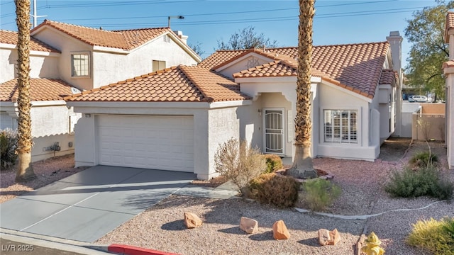 mediterranean / spanish home with a garage, driveway, a tile roof, a chimney, and stucco siding