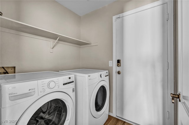 laundry room with washer and dryer and hardwood / wood-style floors