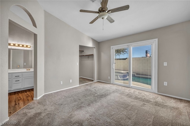 unfurnished bedroom with access to outside, vaulted ceiling, a closet, connected bathroom, and ceiling fan