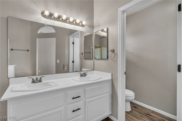 bathroom featuring toilet, vanity, and hardwood / wood-style floors